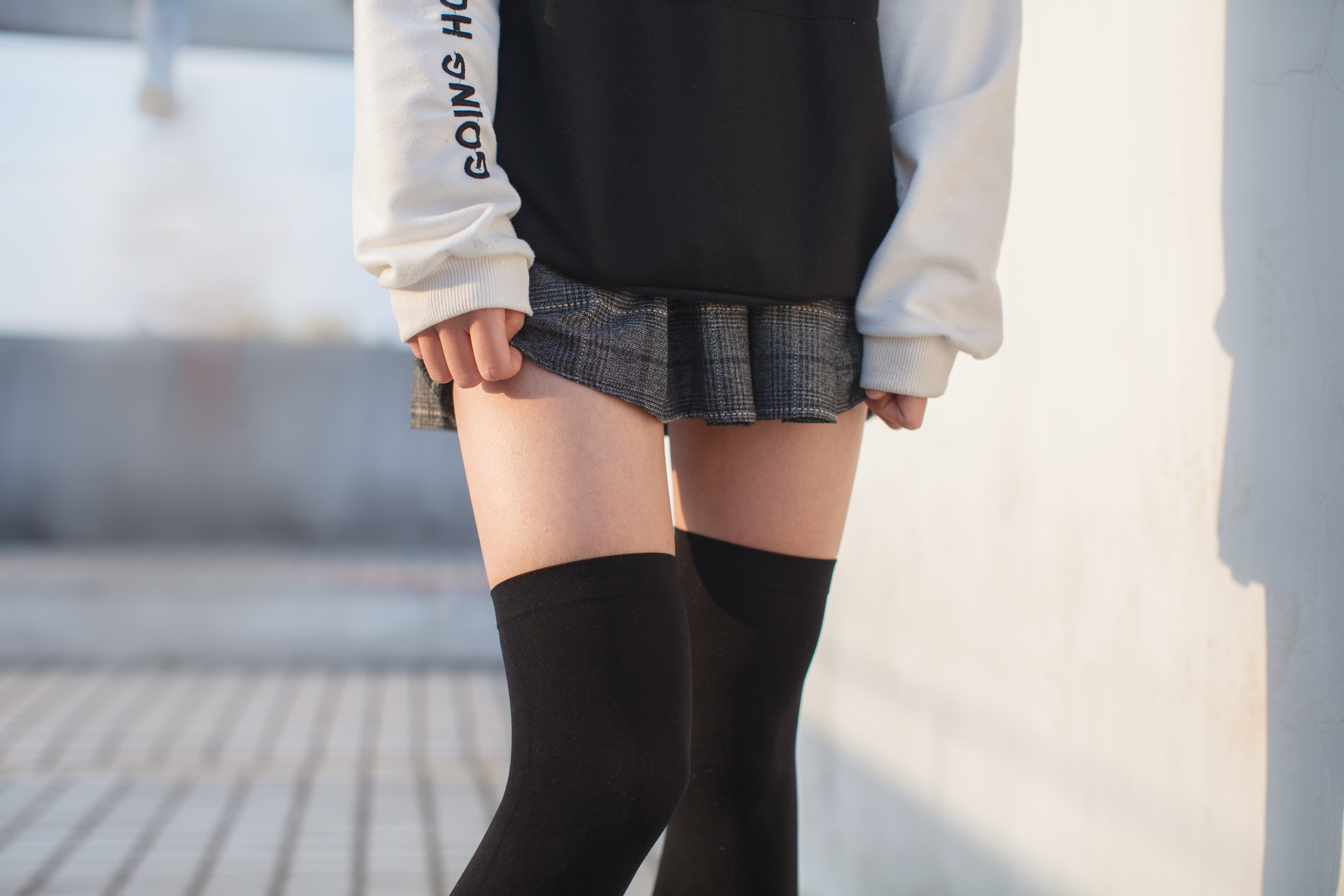Side profile of feet on gravel with sheer hosiery pulled down to heels